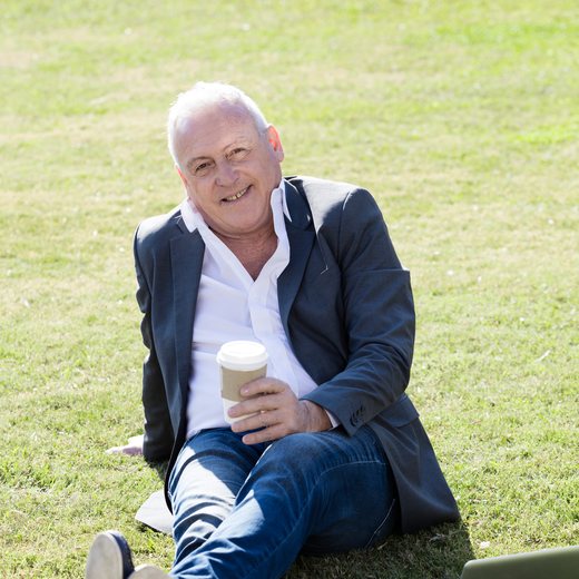An advisor sitting outdoors with a coffee